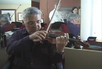 Pinchas Zukerman demonstrates his point surrounded by Canadian students